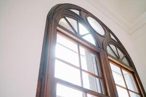 Arched wooden window in a room of an ancient villa photo