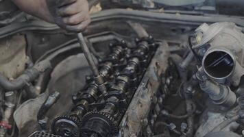 With the workshop as his canvas and tools as his brushes, the mechanic artfully tightens the camshaft pin on a diesel engine, creating a mechanical masterpiece. video