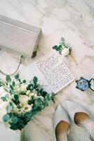 Montenegro, Budva - March 09, 2024. Oath lies on the table next to the bride purse and shoes. Top view photo