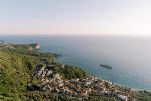 View from the mountain to the resort town with red tiled roofs on the seashore photo