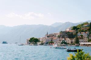 Excursion boats are moored off the coast of Perast against the backdrop of mountains. Montenegro photo