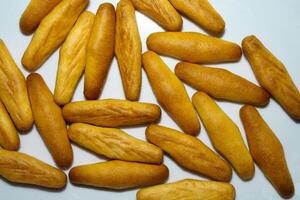 A bunch of bread sticks on a white surface photo