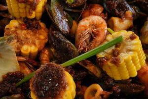 a plate of food with corn, shrimp and other vegetables photo
