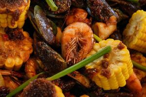 a plate of seafood and corn on the cob photo