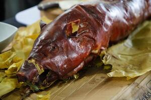 a pig is sitting on a wooden cutting board photo