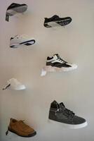 a wall with several pairs of shoes on display photo