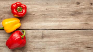 Three red, yellow and green bell peppers on a wooden table photo