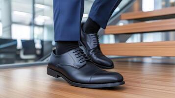 A man in a suit and black shoes is standing on a wooden staircase photo