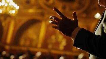 A closeup reveals the intense focus of a government official as they deliver a vital message with their hands poised in midair. The ornate architecture of the hall can be seen blurre photo