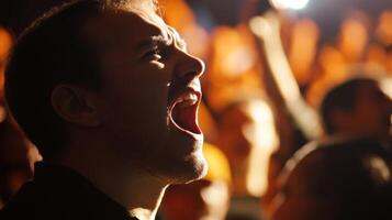Excited man shouting and cheering in a crowd at night photo