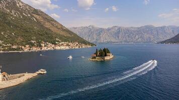 Island of Our Lady of the Rocks, background of the city of Perast in the Bay of Kotor in Montenegro. Aerial view of the island travel destination in the Adriatic Sea photo