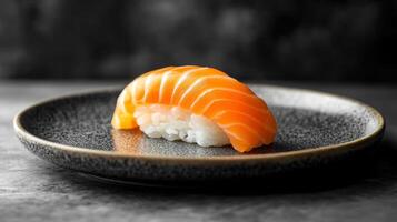 Salmon sushi nigiri on a small dark plate. White rice underneath the fish. Gray concrete surface and dark background. Delicious food. photo