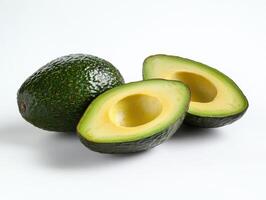 Whole avocado and two avocado halves close up on plain white background showing fresh green skin and yellow flesh inside photo