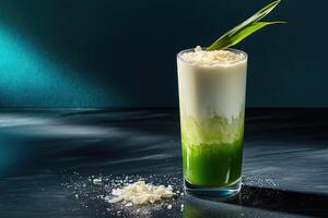 Dramatic shot of pandan coconut milk tea in a faceted glass on a black quartz countertop photo