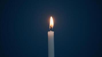 Single Candle Burning Against Dark Background photo