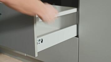 Man assembling kitchen drawer in cabinet using screwdriver. Handyman installing and adjusting drawer slide mechanism in contemporary kitchen video