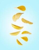 Flying potato chips on blue background photo