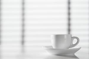 White cup of espresso on the table against the background of the window photo