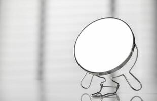 A mirror on a table with a white background photo