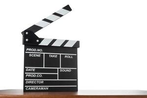 Movie clapperboard on table on white isolated background photo