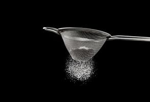 Sifting flour through a sieve photo
