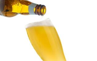 Pouring beer into glass on isolated background photo