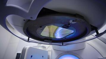 Low angle view of a linear accelerator cancer radiation machine spinning around a patient. Magnetic resonance imaging, medical examination. Medicine concept, technology video