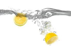Cut lemon falls into water photo
