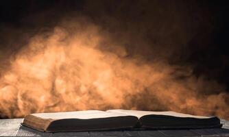 Open book on the desk in a backlight with smoke on the background photo