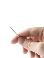 Hand with toothpick on white isolated background photo