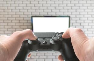 Gamepad in hand with tv on background photo
