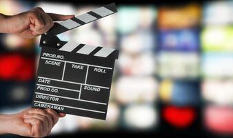 Clapperboard in hands on the background of TV screens photo