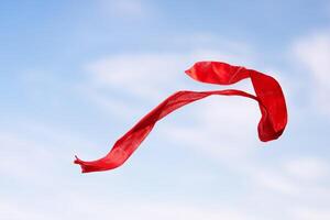 Red ribbon on a background of blue sky photo