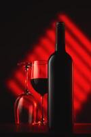 Wine bottle and glasses on red abstract background photo