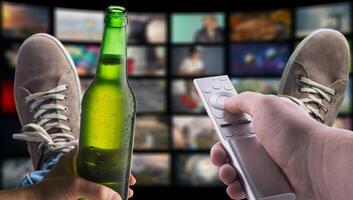 Two people holding a remote control and a beer bottle photo
