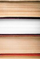 A stack of books with a white book in the middle photo