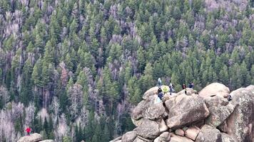 Explorers navigate rocky terrain atop a mountain in Colorado's scenic wilderness during early spring video