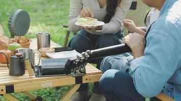 A couple is sitting at a picnic table with food video