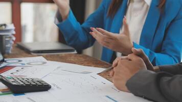 Business people discussing financial documents at a desk video
