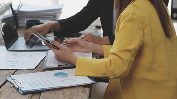 A man and woman sitting at a table with laptops and papers video