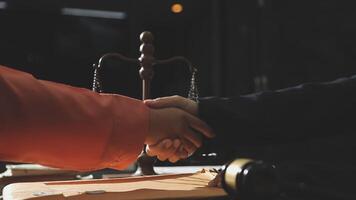 Two people shaking hands over a table with a scale video