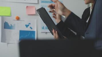 A man in a suit is pointing at a tablet video