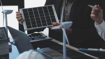 A man and woman are working on a laptop with solar panels video