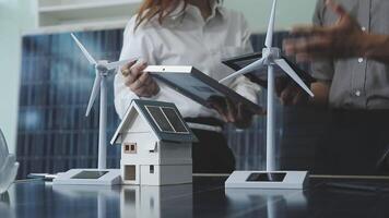 Two people standing near a house with wind turbines video