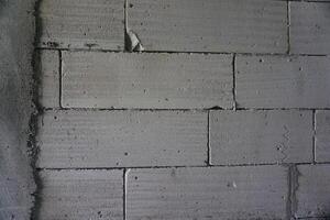 Grey concrete block wall texture indoors, construction site background photo