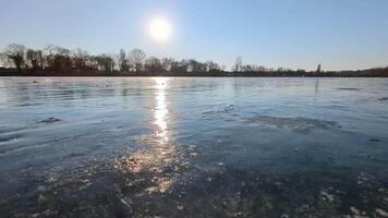 Walking on ice covering a frozen winter river with cracks, air bubbles and frozen algae are visible in the ice video