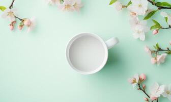 A white cup with water sits on a green background with pink flowers photo