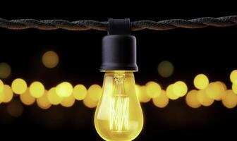 Vintage yellow light bulb hanging against a dark background with bokeh effect creating a warm and inviting ambiance for decoration or photography projects photo