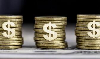 Stacks of shiny gold coins with dollar symbols arranged on a surface, representing wealth, finance, and investment opportunities for business growth photo