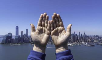 Hands reaching up to the sky with a city in the background photo